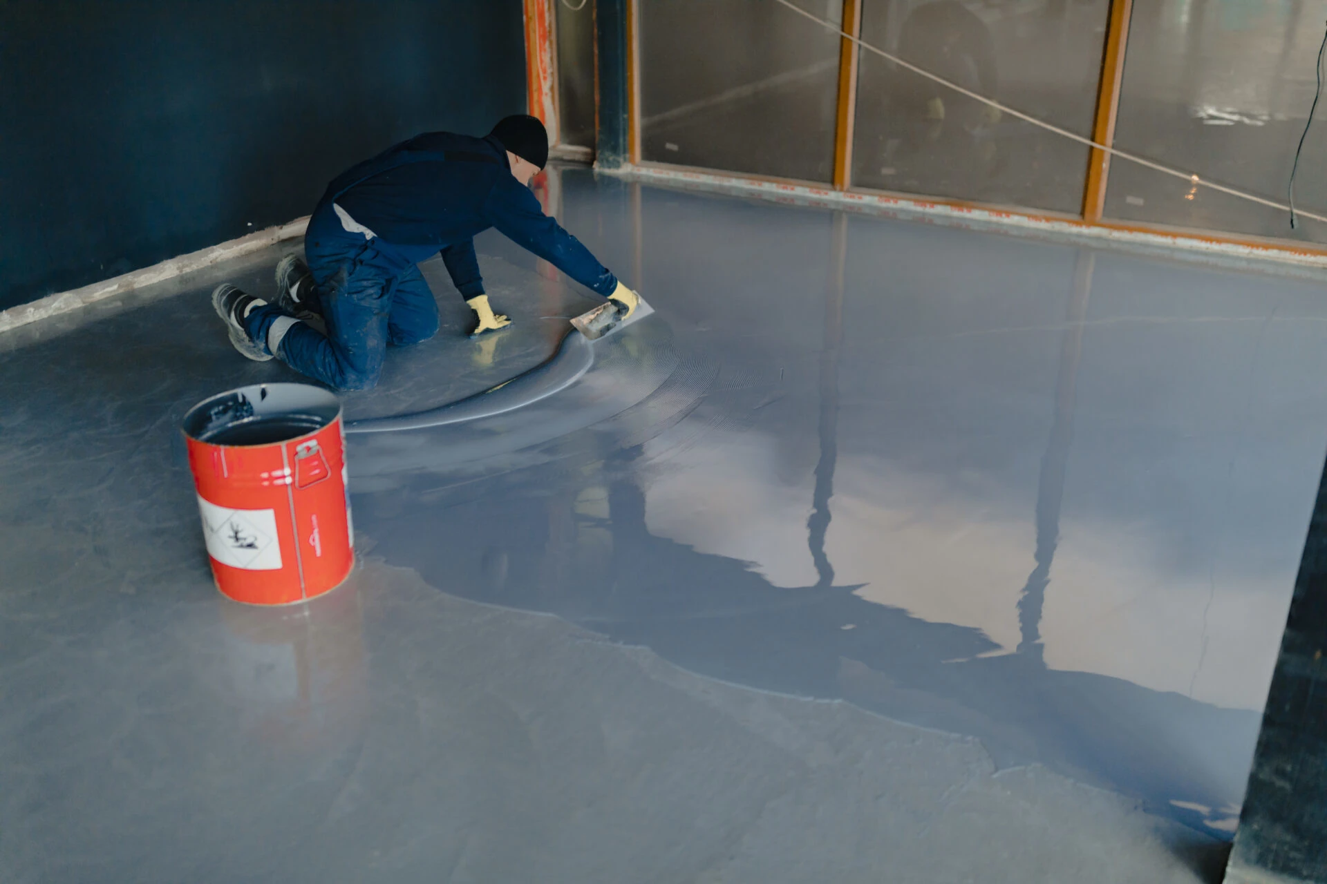 Epoxy floor application in progress showing blue coating