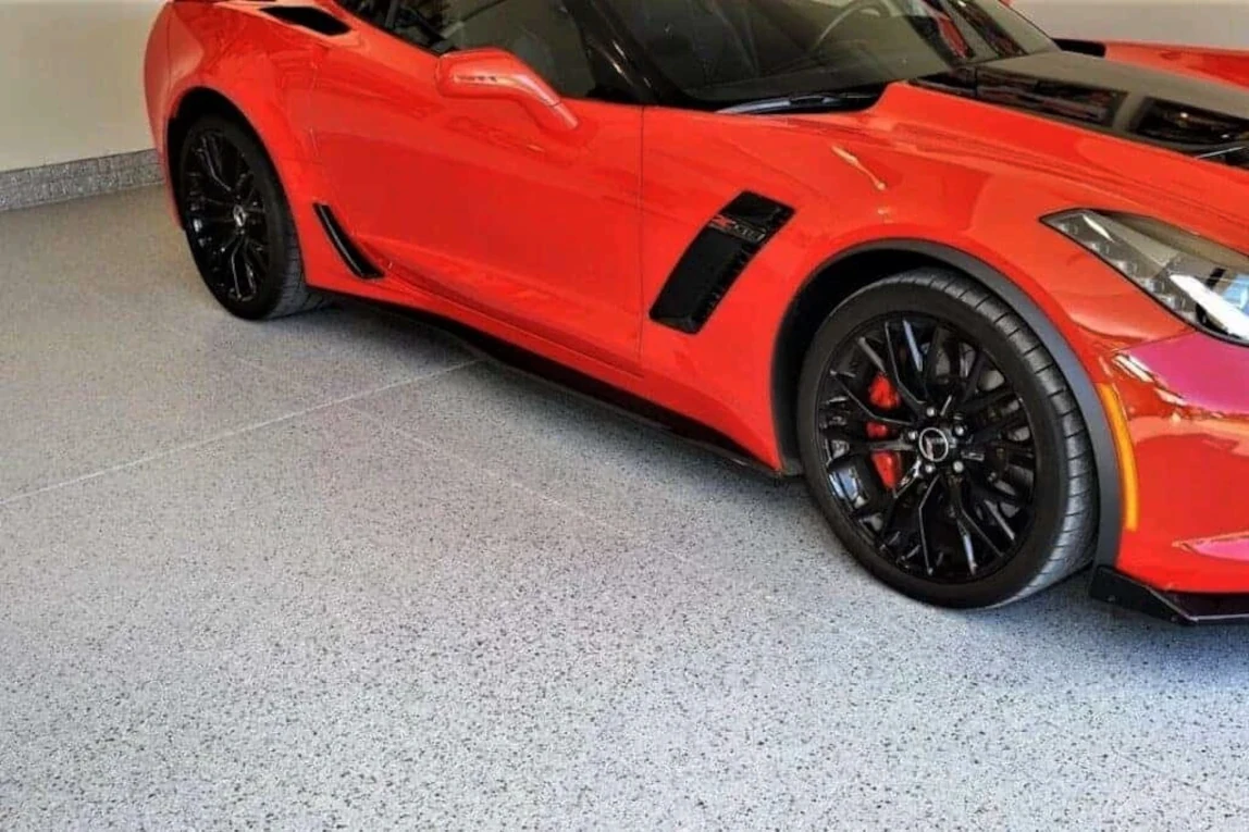 Garage epoxy floor with large flecks supporting a sports car