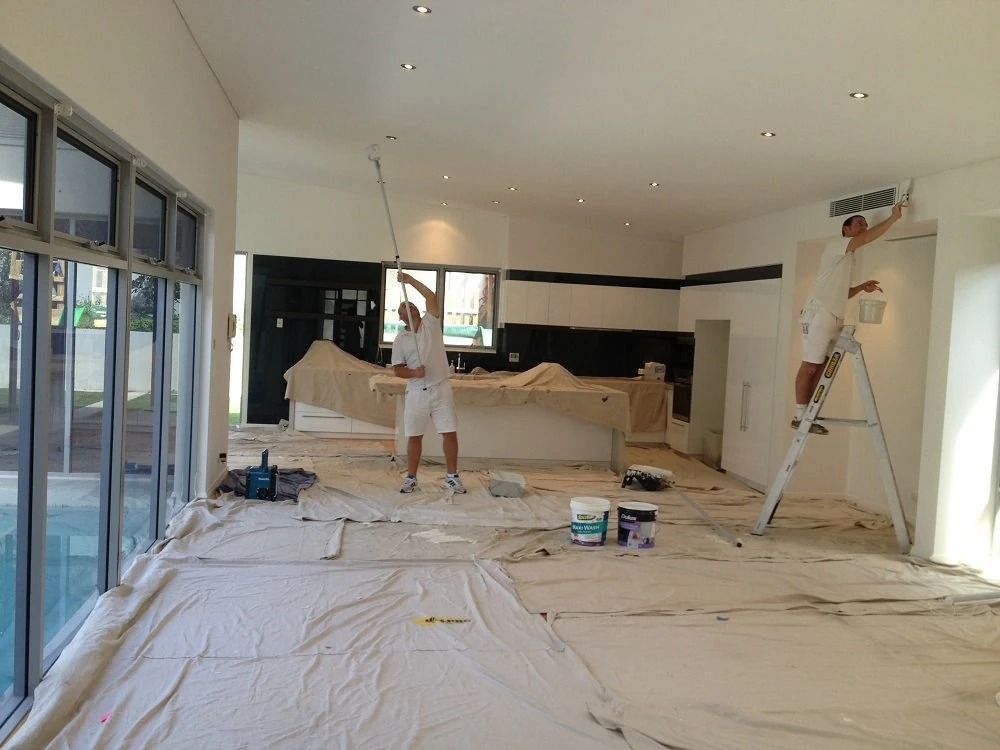 Professional painters preparing a room with protective coverings